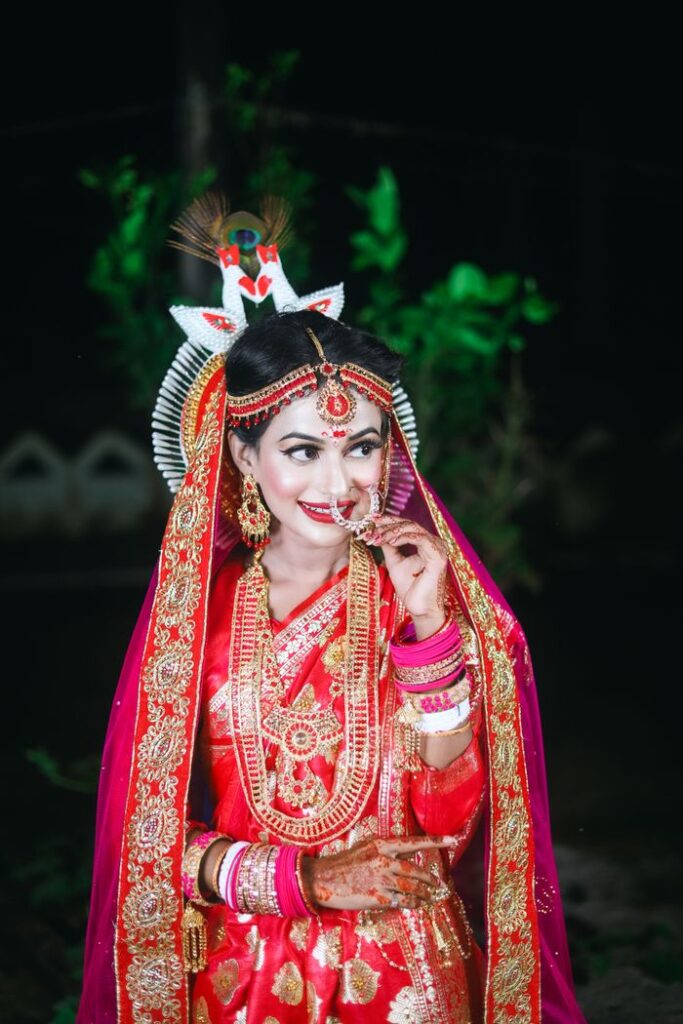 A beautiful bride in traditional red and gold attire, showcasing intricate jewelry and elegance.