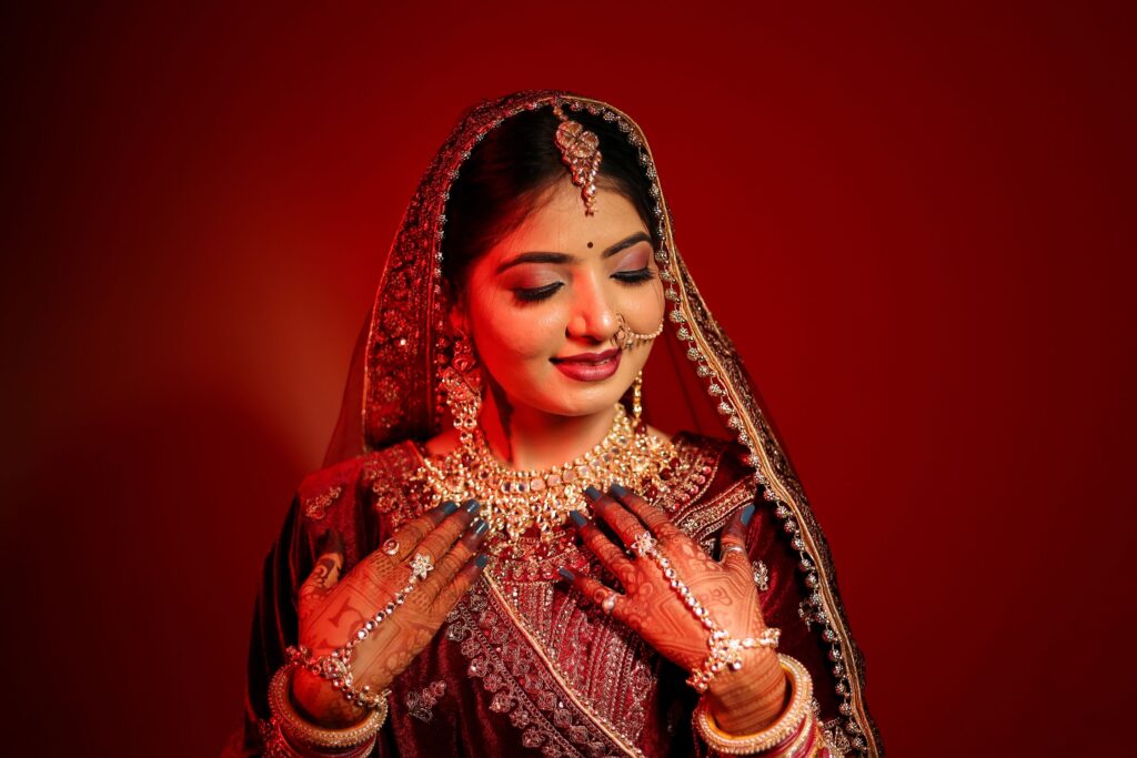 Stunning Indian bride in vibrant traditional bridal wear with intricate jewelry and henna.