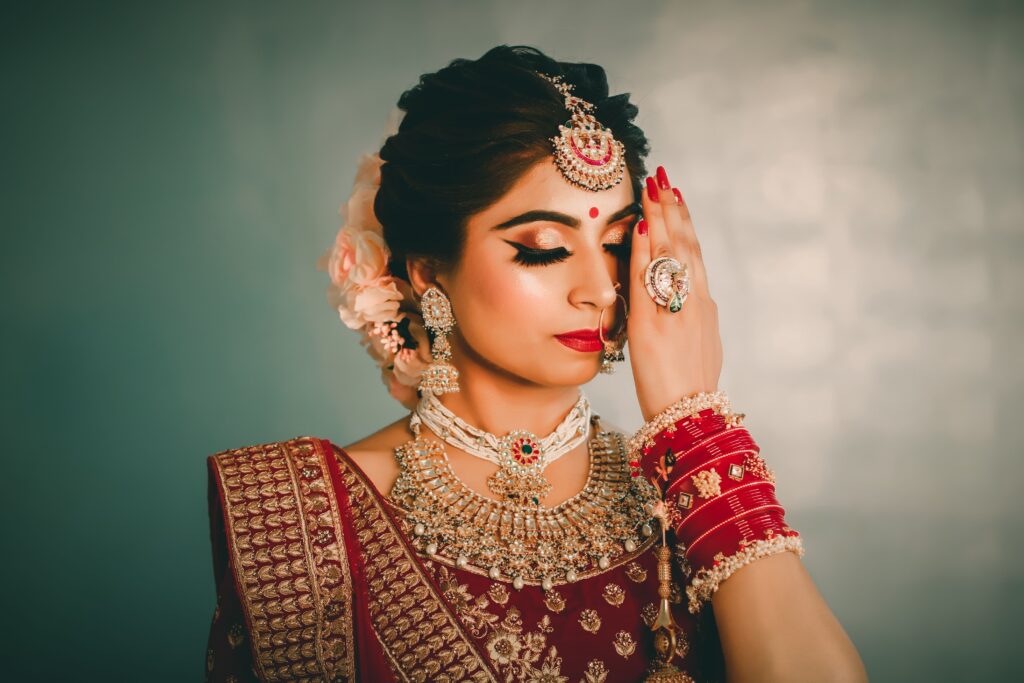 Young ethnic female with bright makeup and black eyeliner in national costume closing eyes